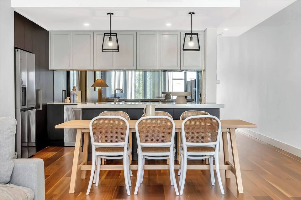 Gather around the timber table under soft lighting for meals, games or planning the day’s coastal adventures.