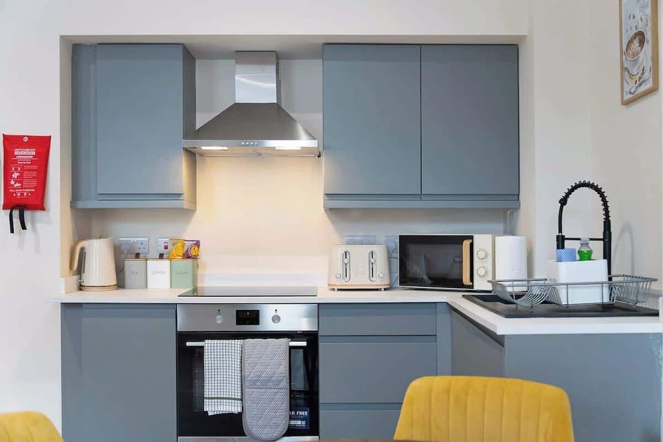 Kitchen equipped with all essentials, including a microwave, kettle, toaster, and full cookware set.