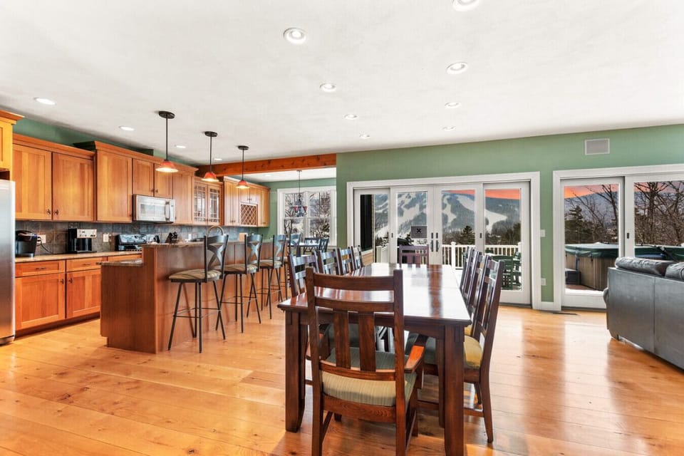 Large 10-person dining table and the open-concept kitchen with seating for 4 more at the bar and another 4 at the breakfast nook