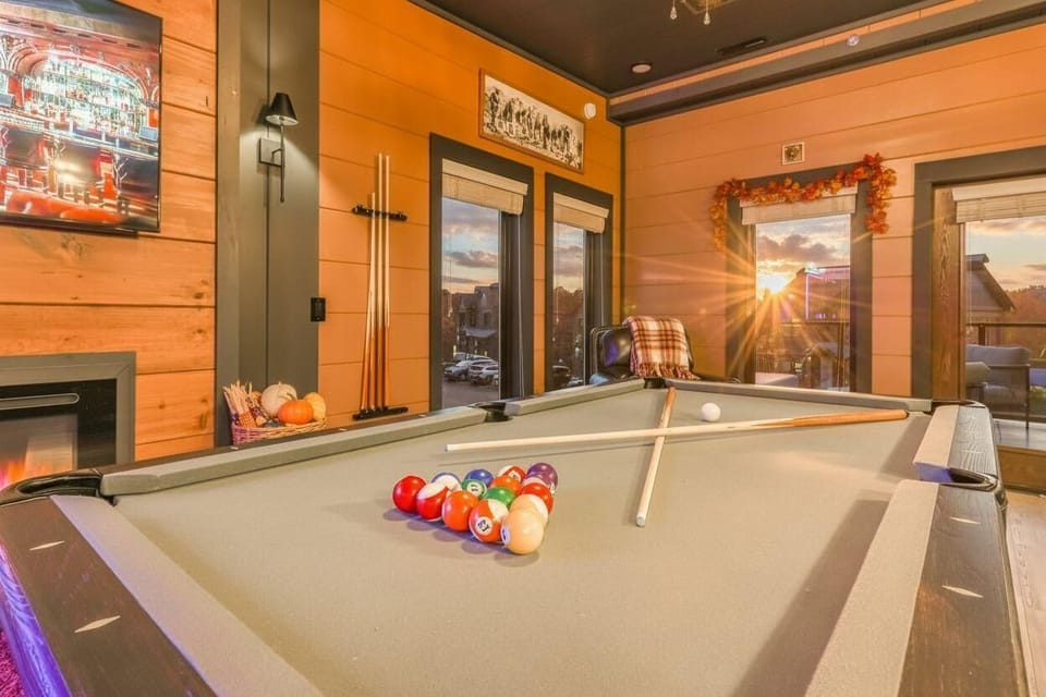 sunset lighting highlights the rustic game room with a pool table and cozy seating