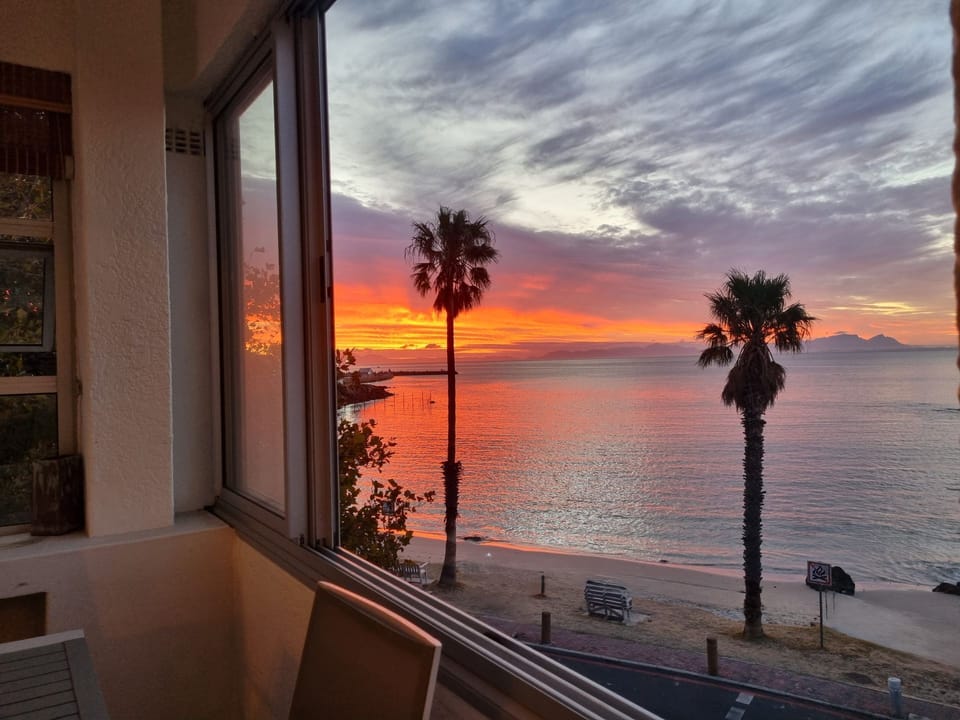 Enjoy a beautiful sunset view of the beach from an enclosed balcony. 