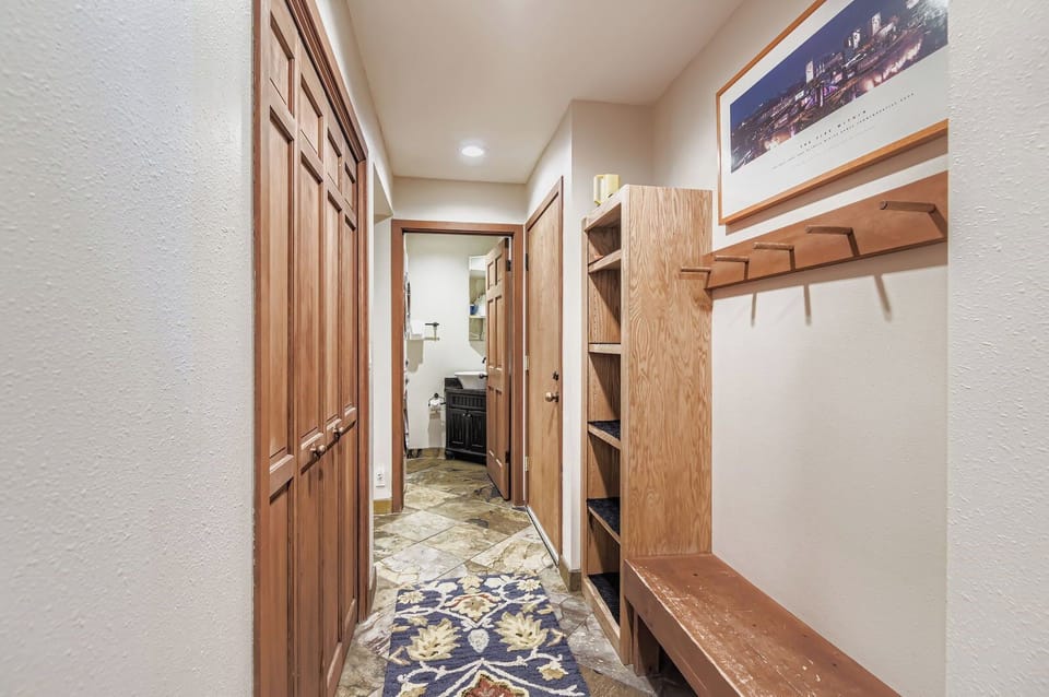 Welcome to this cozy mountain retreat! This inviting entryway features a rustic wooden bench, built-in shelves, and convenient in-unit laundry access.