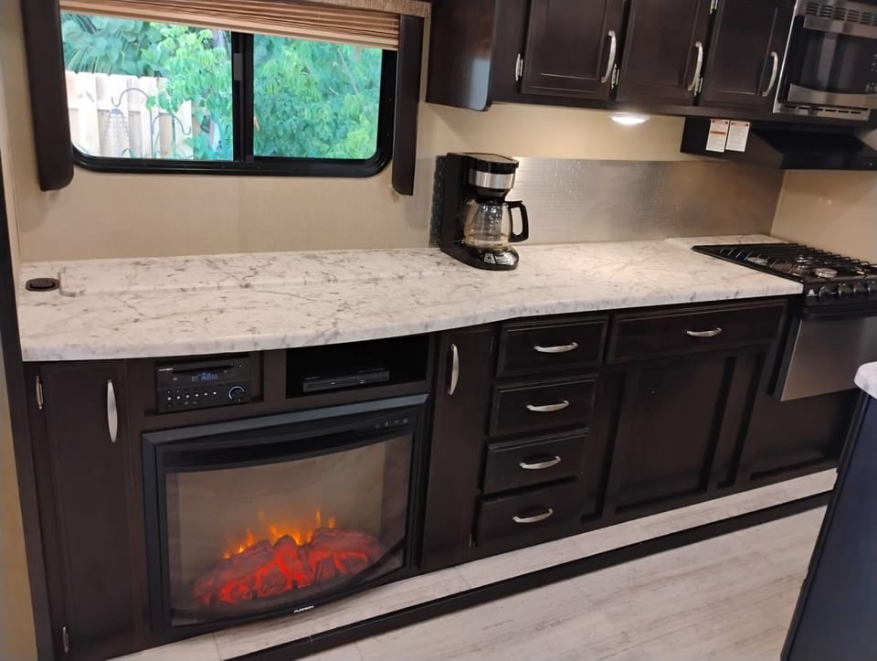 Large counterplace w/ coffee pot and gas stove.