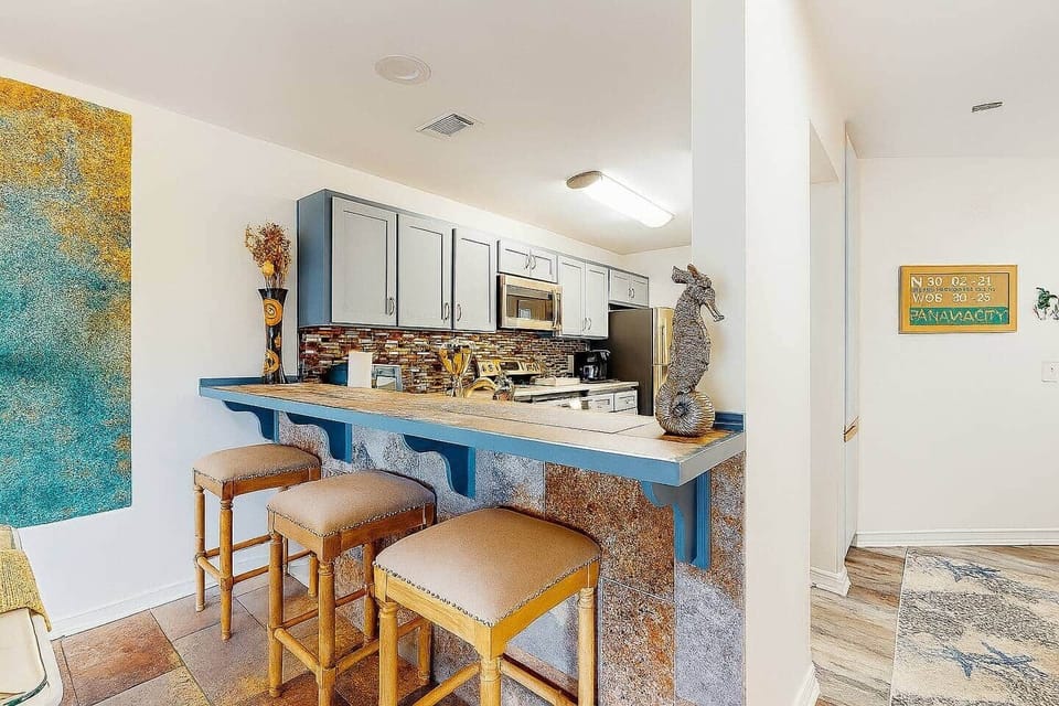 Breakfast bar with seating for three and a fully equipped coastal kitchen