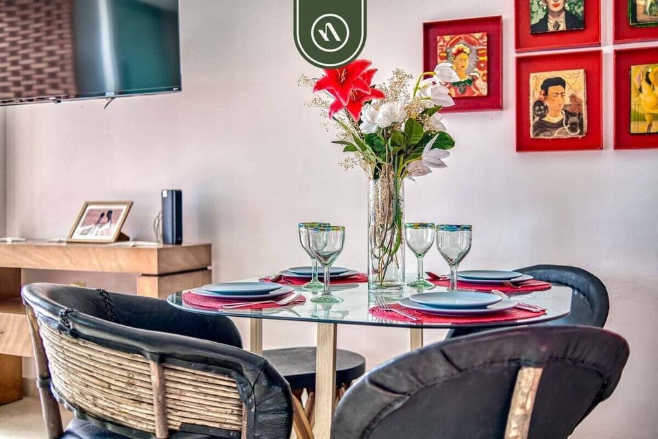 Gather for meals around the glass table featuring authentic Mexican equipal chairs. The bright, open space connects seamlessly to the modern kitchen for easy entertaining.