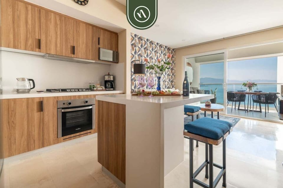 A modern, fully equipped kitchen that opens directly to the balcony, allowing natural light and ocean breezes to flow through while you cook or dine.