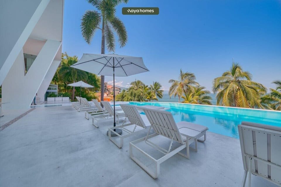 Enjoy resort-style living with a sleek infinity pool, sun loungers, and sweeping coastal scenery.