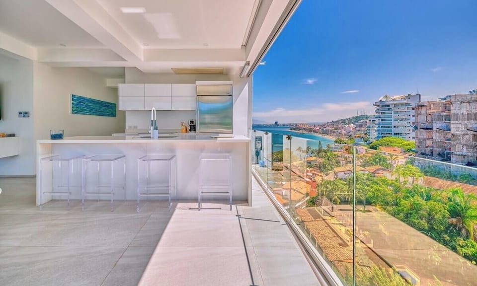 A sleek, fully equipped kitchen with modern appliances, bar seating, and a bright open layout ideal for gathering.