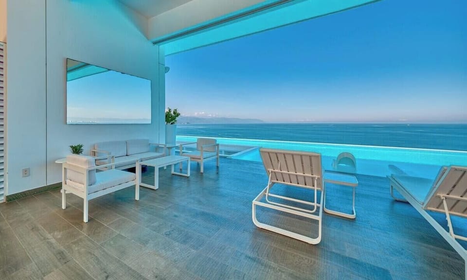 Enjoy resort-style living with a sleek infinity pool, sun loungers, and sweeping coastal scenery.