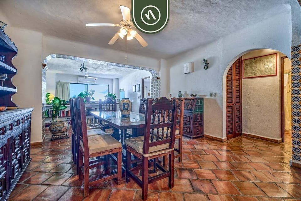 A perspective from the living area looking back through wide arches into the connected traditional dining room.