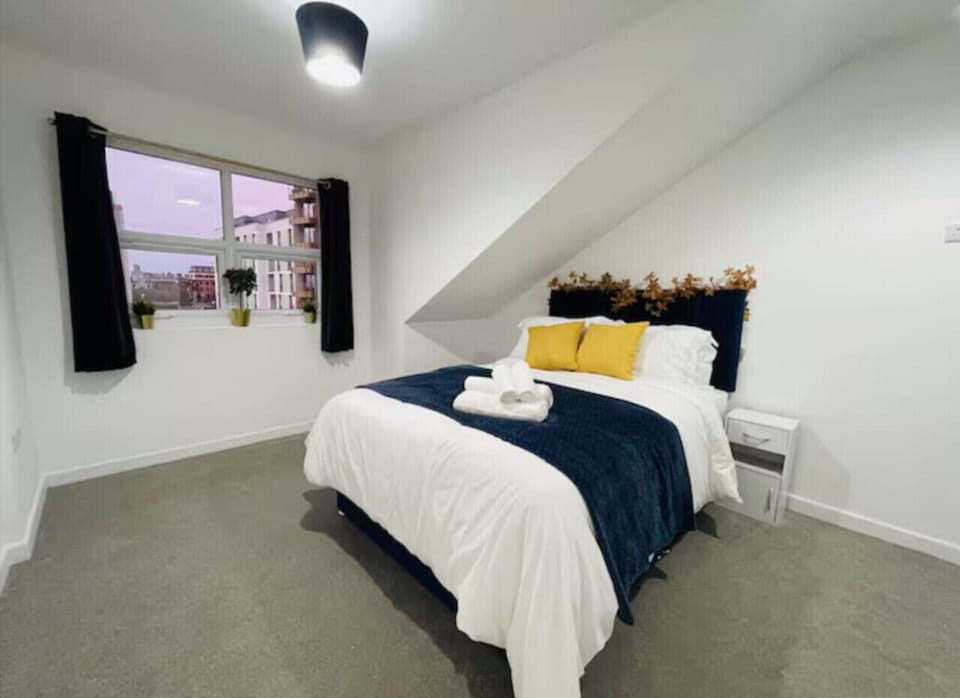 Cozy bed with fresh linens, blackout shades, and storage.