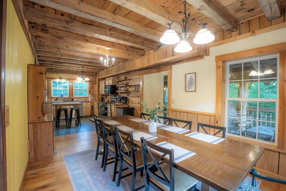 A long farmhouse table set for shared meals and late-night card games alike.