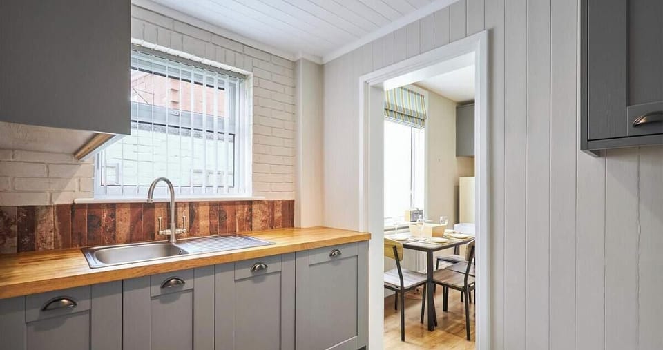 Modern kitchen with sleek cabinetry and warm wood countertops.