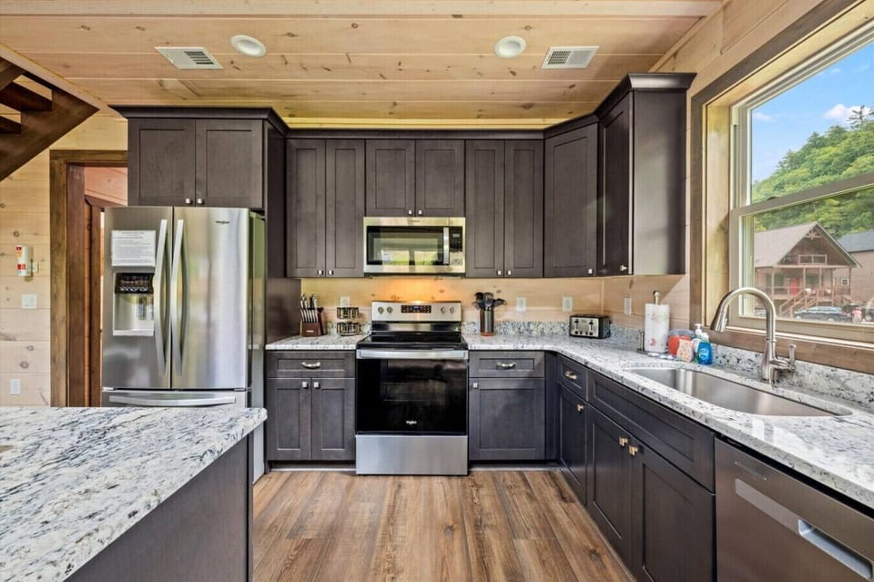 With sleek dark cabinetry, plenty of counter space, and all the essentials, this kitchen is designed for both style and convenience.
