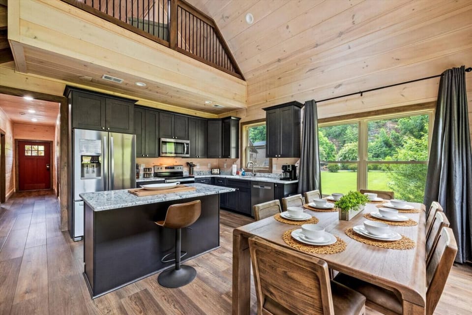 Gather around this bright and open kitchen where granite countertops, stainless steel appliances, and rustic wood details blend modern comfort with Smoky Mountain charm.