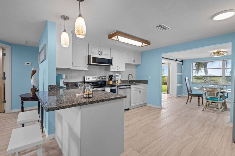 Fully equipped kitchen with granite counters and modern appliances, ideal for preparing home-cooked meals.