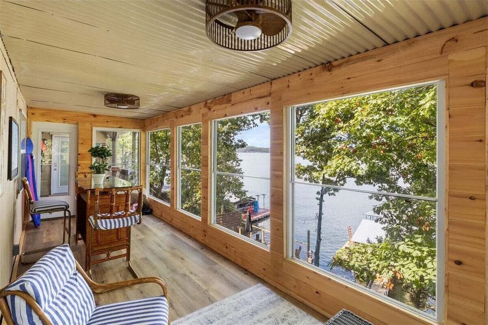 Enclosed sunroom with surrounding views of the lake