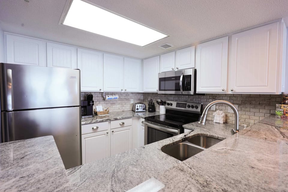 This fully equipped, modern kitchen features stainless steel appliances and ocean-view charm—perfect for whipping up a hearty breakfast before hitting the beach for the day!