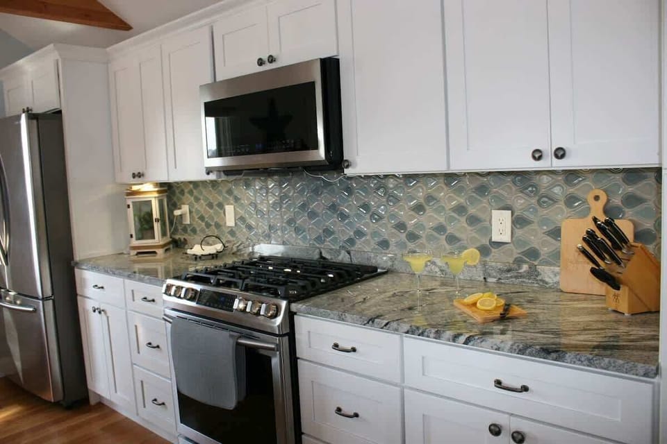 Coastal charm in every detail: Beachy backsplash, modern appliances, and generous counter space.