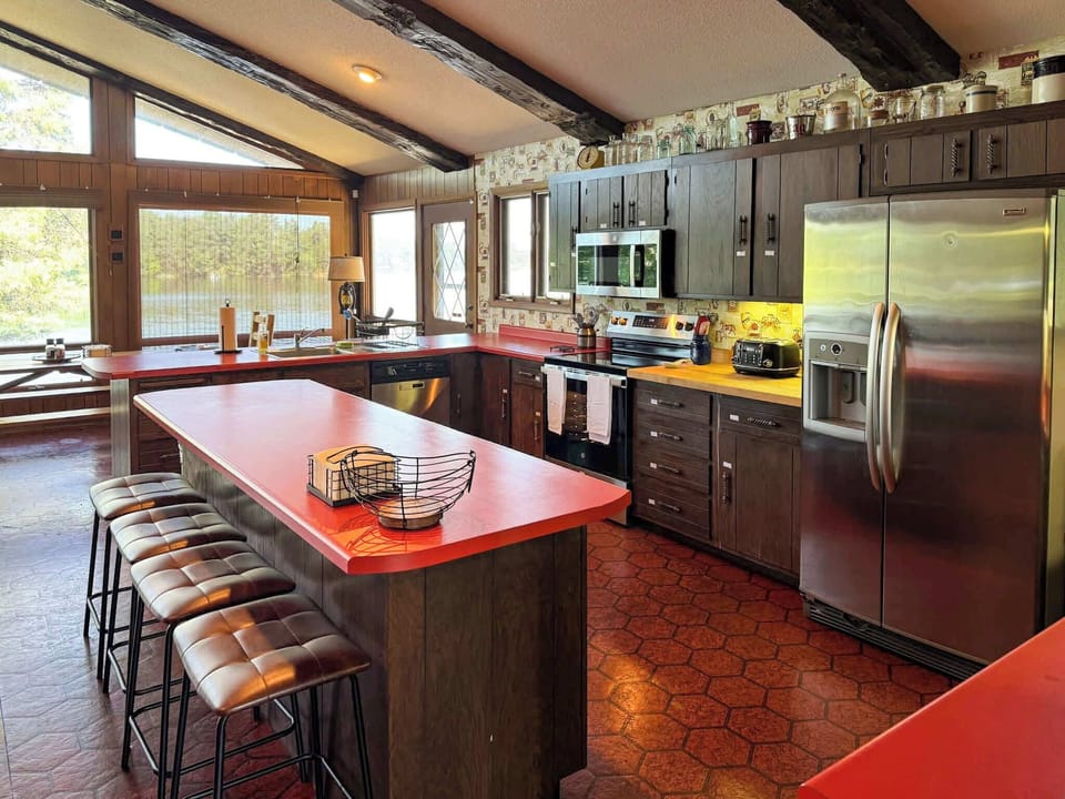 View of the full kitchen looking at the lake and with visibility across the entire great room, dining, living room, entertainment space