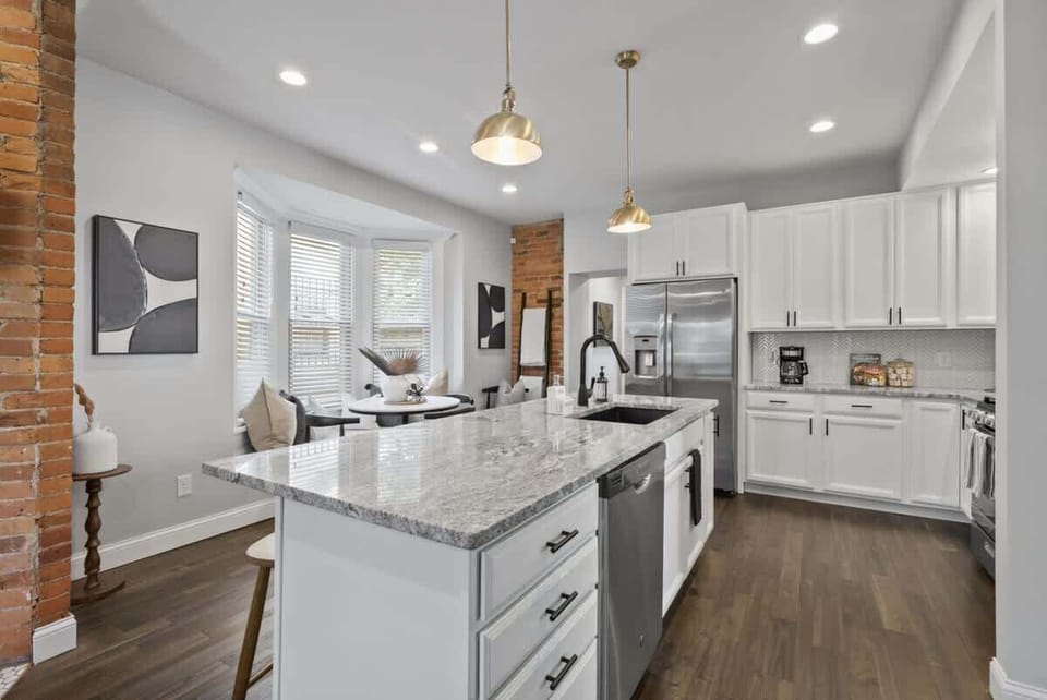 Bright kitchen w/ large marble island, modern appliances, & open flow to the living area
