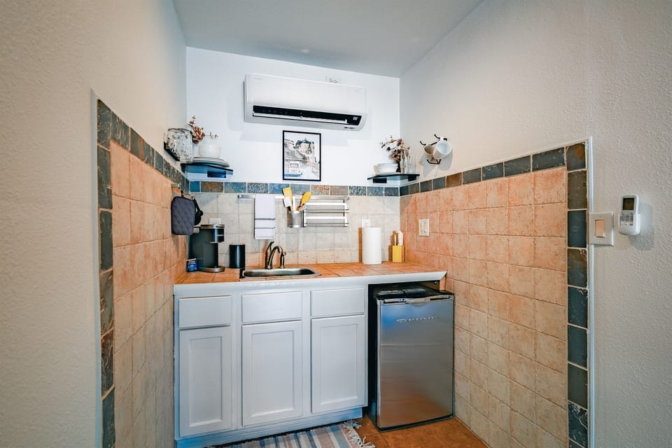 A charming kitchenette with a mini fridge, microwave, sink, and coffee maker—perfect for light meals and morning brews.