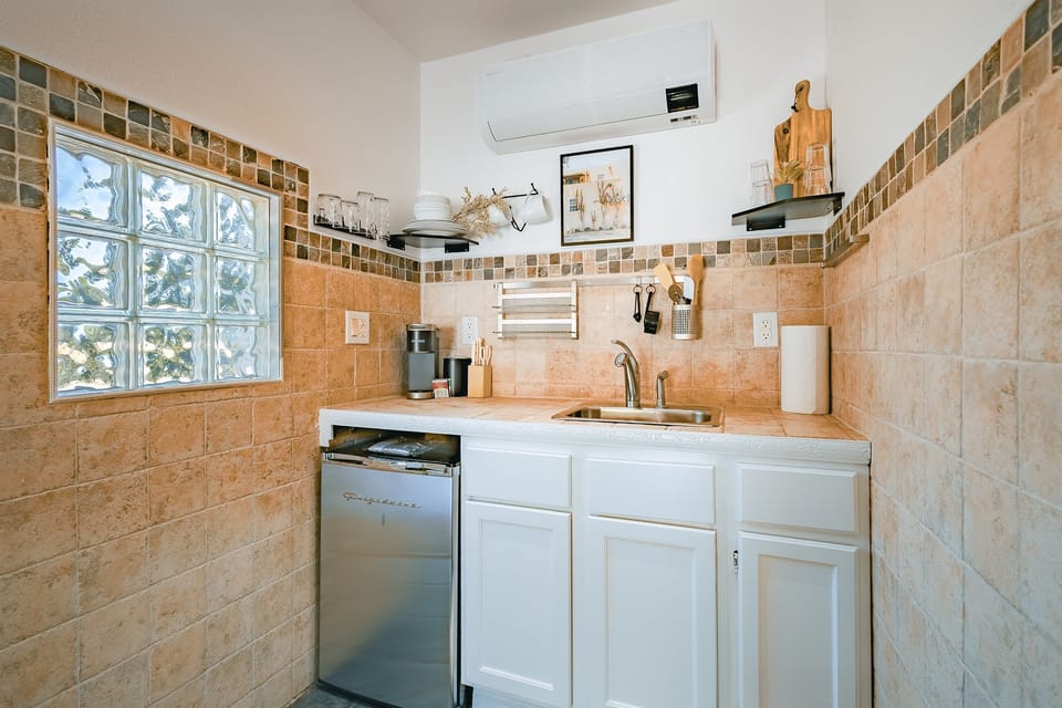 A charming kitchenette with a mini fridge, microwave, sink, and coffee maker—perfect for light meals and morning brews.