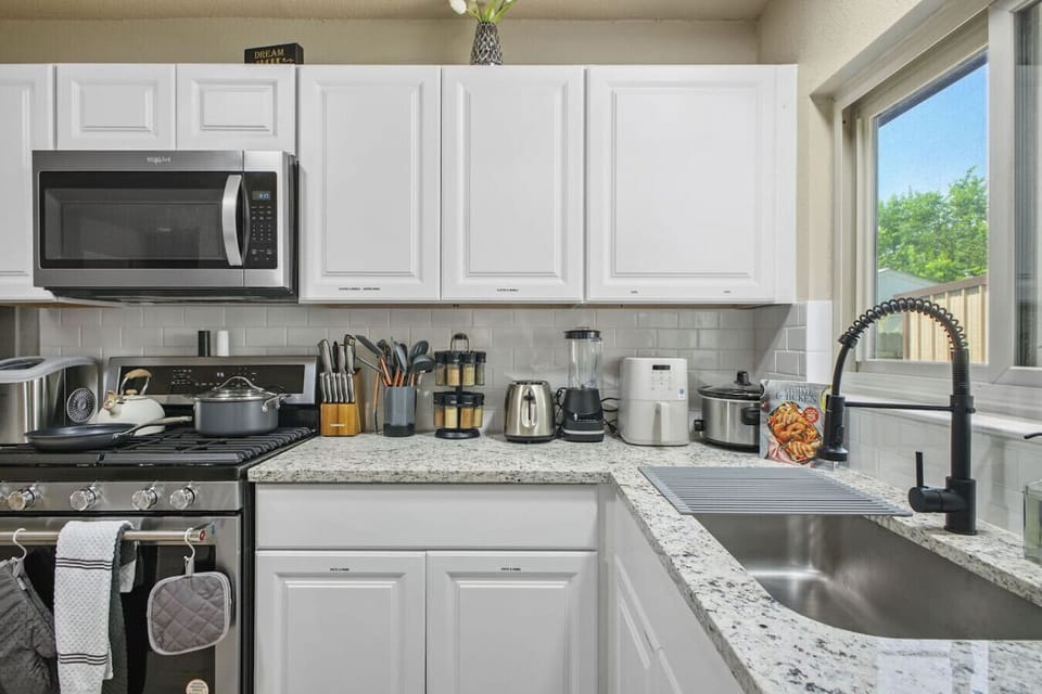 Modern, fully stocked kitchen with stainless steel appliances, granite countertops, and a full coffee station. Bright, functional, and perfect for everything from quick breakfasts to home-cooked dinners.