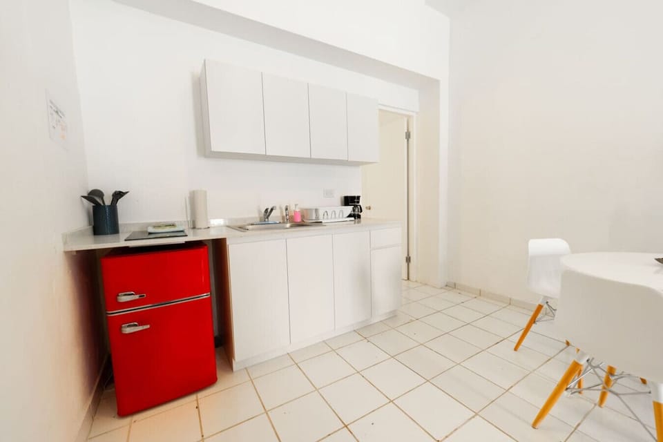 The compact and efficient kitchenette includes a sink, counter space, and a fun retro-style fridge for your convenience.