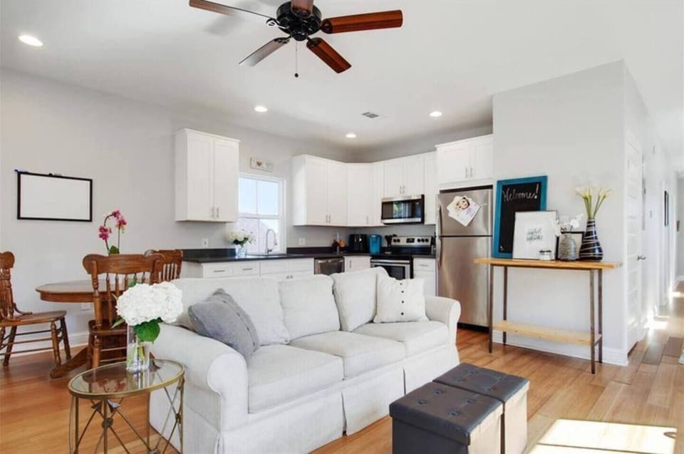 Airy living room w/ a comfy couch — light, white & made for lounging.
