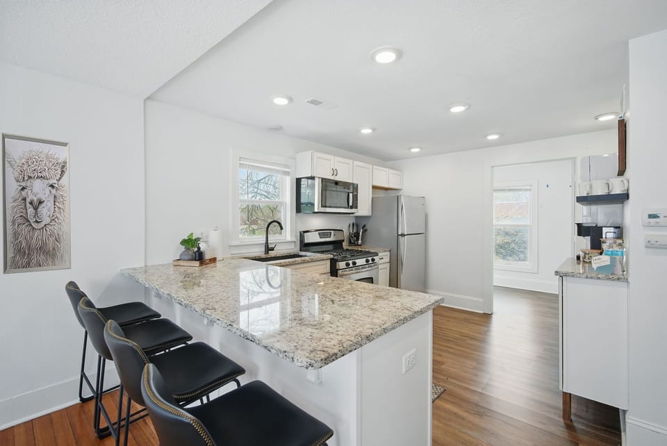 Fully stocked kitchen with stainless appliances, granite countertops, and bar seating—perfect for cooking, snacking, or sipping wine.