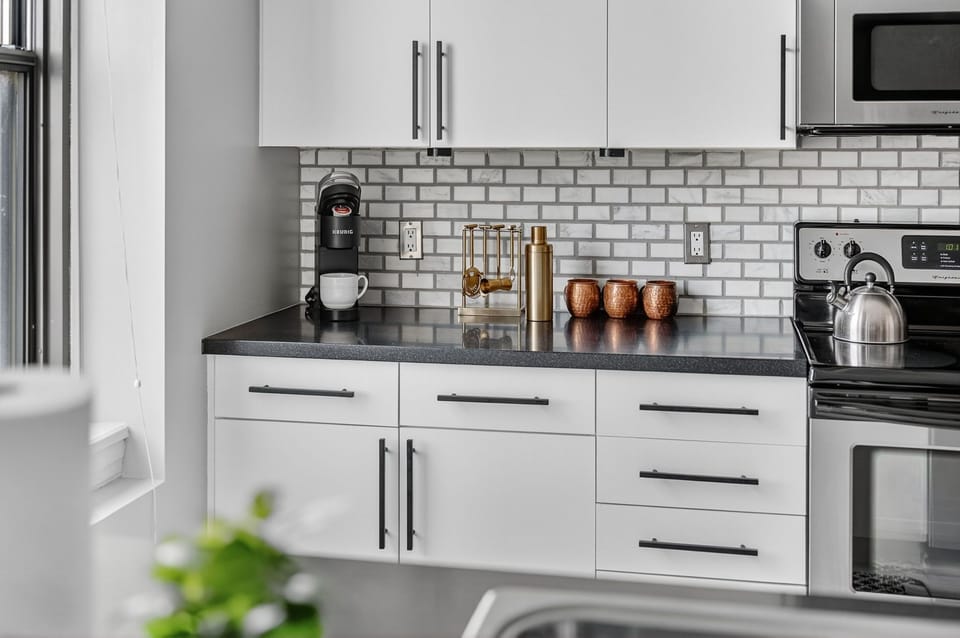 Sleek and functional—your modern kitchen comes stocked with essentials, including a Keurig, barware, and plenty of prep space for takeout or home-cooked meals.