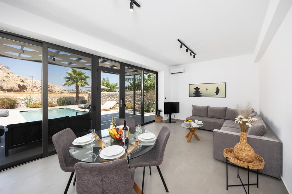 Open-plan living room with sofa, dining area, kitchen, A/C, WiFi internet, and satellite TV