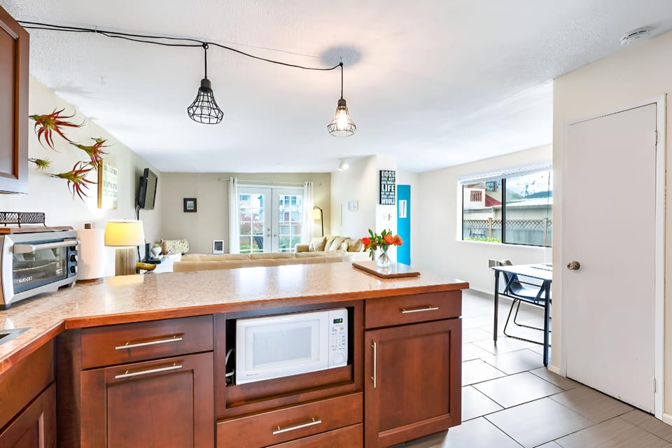 Kitchen bar shown here. Also microwave and toaster oven are visible. Imagine serving breakfast to your beloved here over a cup of coffee.