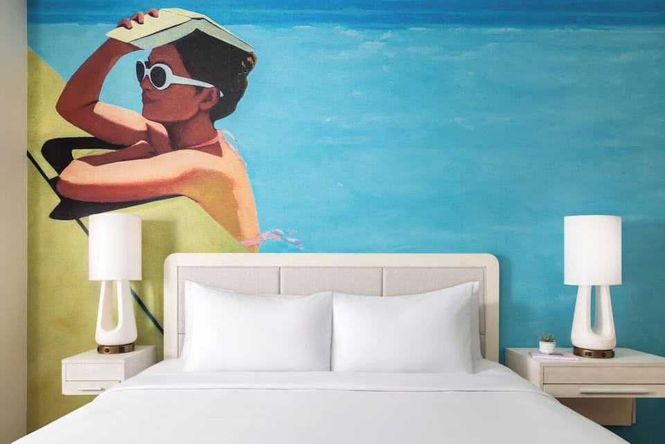 Drift off beneath vibrant beach art and plush pillows.
