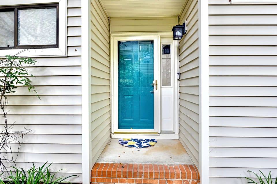 Front door entrance (accessed from right side of home) with smart lock on door.