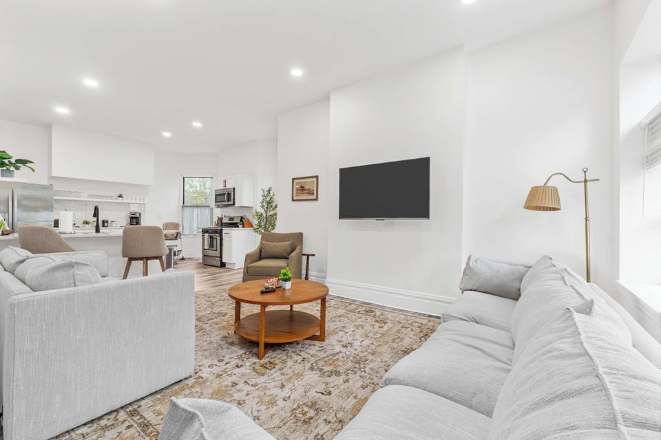 This bright living room, adorned with white walls, is the perfect backdrop for laughter, relaxation, and movie marathons. 
