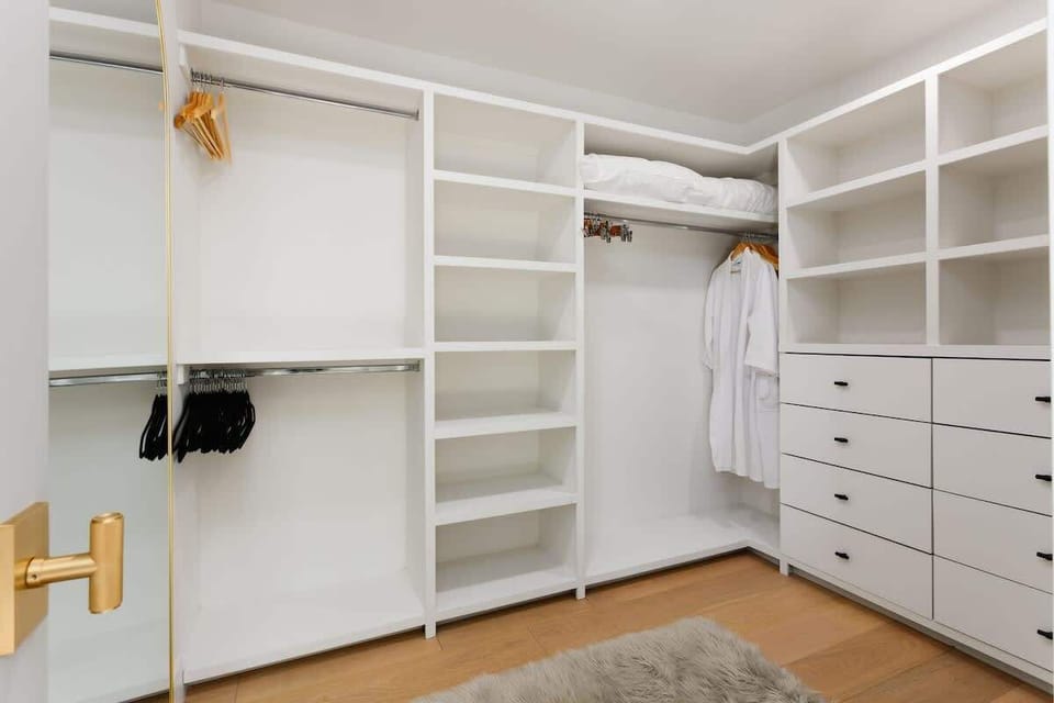 Primary bedroom with a King bed, large walk-in closet, en-suite bathroom, and private access to outdoor patio.