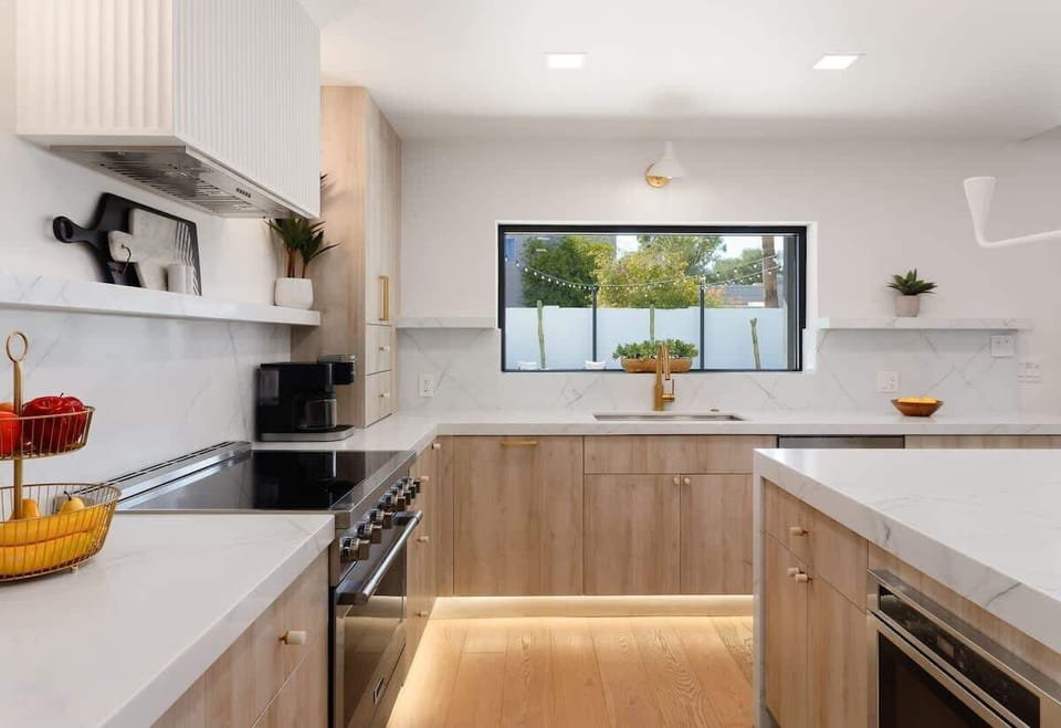 Fully equipped kitchen with stainless steel appliances, a sleek kitchen island with a breakfast bar for casual seating for 4.