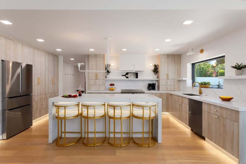 Fully equipped kitchen with stainless steel appliances, a sleek kitchen island with a breakfast bar for casual seating for 4.