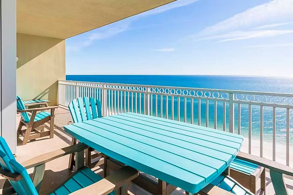 This spacious balcony features a turquoise table and chairs, perfect for enjoying a beachfront view and relaxing moments