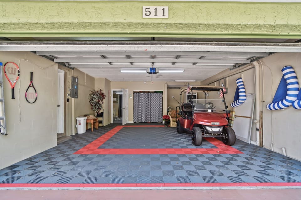 Garage with rubber flooring and washer/dryer.