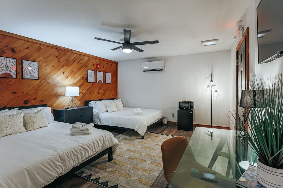 Charming suite with two queen beds, desk, and rustic wood accents.