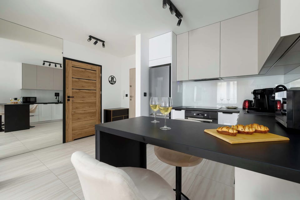 View from kitchen area with breakfast bar, modern appliances, and light flooring.