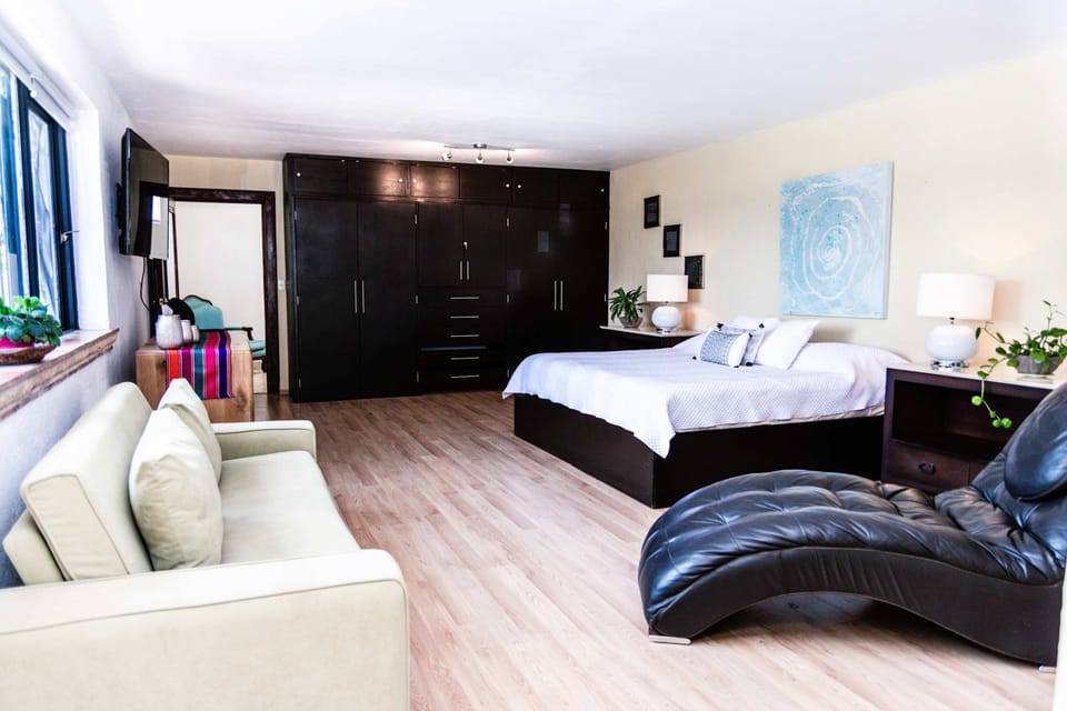 Bedroom 1 | Elegant suite with king bed and additional sofa bed, overlooking the pool