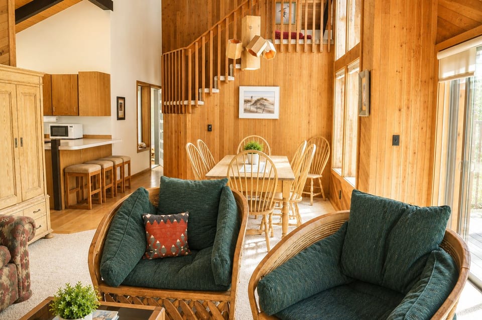 Warm wood tones and soaring ceilings create your perfect retreat. Sink into cozy seating, gather at the dining table, and feel right at home in this sunlit, open-concept space.