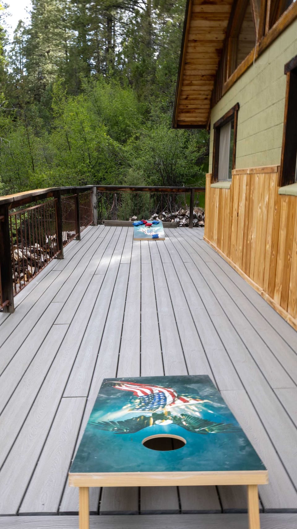 Play cornhole on the spacious upper deck with forest views and crisp mountain air.
