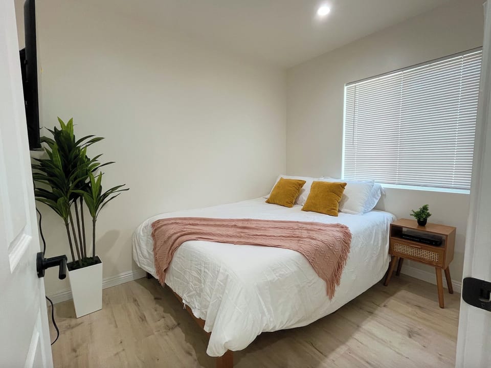 Queen bed with smart TV (left) and closet (right of nightstand).