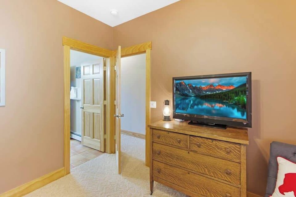 Bunk bedroom equipped with a smart tv and is adjacent to a jack and jill bathroom.