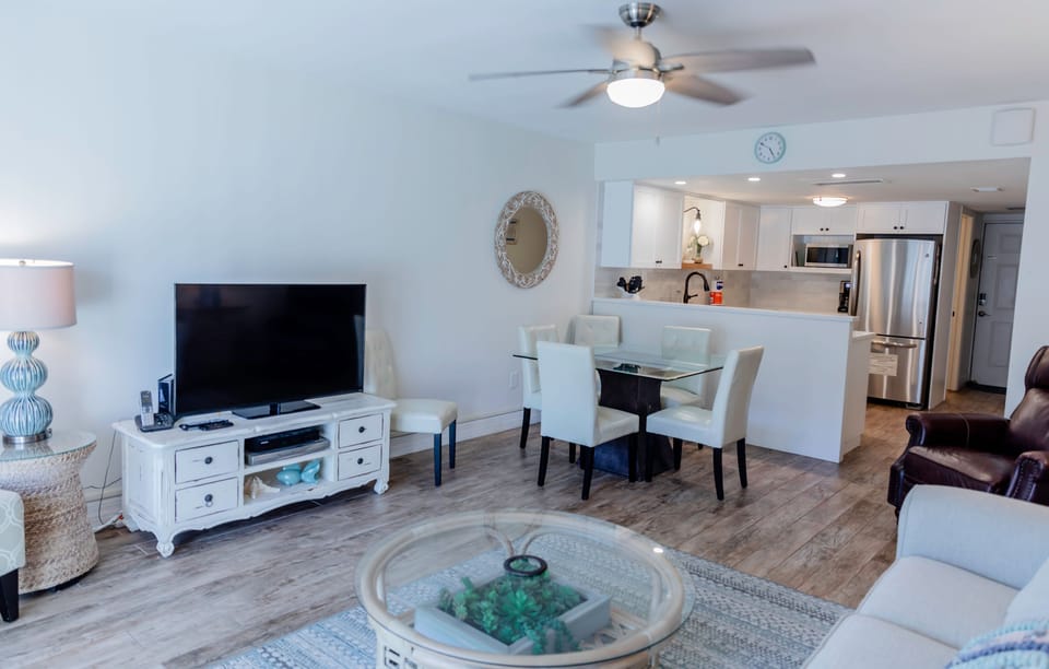 Enjoy your beach stay in this stylish open-concept condo featuring a cozy living area, modern kitchen, and dining space—perfect for relaxing after a day of sun and surf.